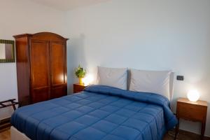 a bedroom with a blue bed and a wooden cabinet at Villa Marianna in Vasto