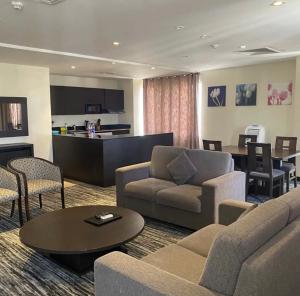 a living room with a couch and chairs and a table at Golden Tulip Oniru Suites in Lagos