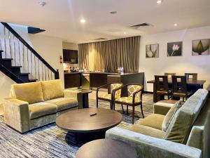 a living room with couches and chairs and a table at Golden Tulip Oniru Suites in Lagos