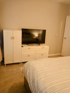 1 dormitorio con 1 cama y TV de pantalla plana en Sloanehill en Killyleagh