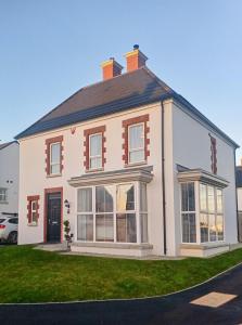 una casa blanca con techo de gambrel en Sloanehill en Killyleagh