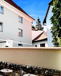 a view of a building with chairs and a fence at Pension MONO - Adults Only in Český Krumlov