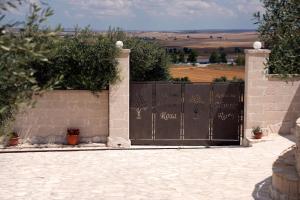 Una cerca con una puerta con escritura. en Agriturismo Nonna Rosa, en Matera