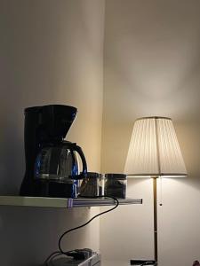een koffiezetapparaat op een glazen plank naast een lamp bij شقة فاخرة بالقرب من البوليفارد Apartment next to boulevard city- world &arean kingdom in Riyad