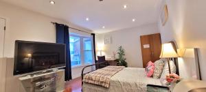 a bedroom with a large flat screen tv and a bed at Main Floor Spacious Room in Toronto in Toronto