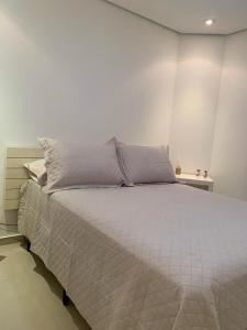 una camera bianca con un grande letto in una stanza di Royal Ibirapuera Park a San Paolo