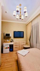 a bedroom with a bed and a television in it at ALTYN in Astana