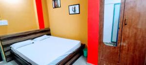 Habitación con cama y pared roja y amarilla. en THE RAJKHOWA PALACE, 