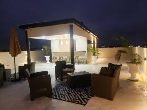 a group of chairs and tables on a patio at night at Malik SuitesGY 