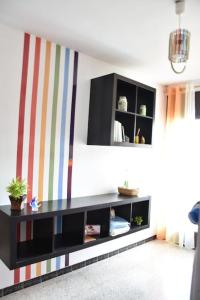 una sala de estar con un armario negro con una pared a rayas en Piso céntrico for2 cerca Barcelona LA CASA DE SONIA en Vilanova i la Geltrú