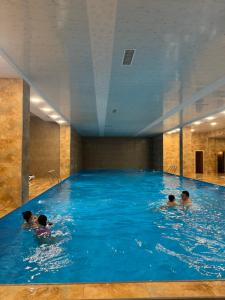 a group of people swimming in a large swimming pool at Apartroom in Tsaghkadzor