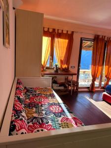 a bedroom with a bed and a table and windows at La stanza dei segreti in Aosta