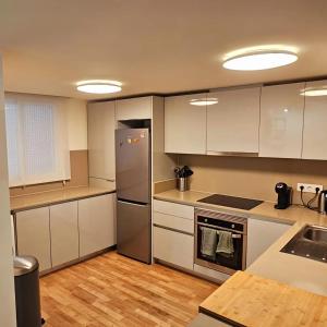 a kitchen with white cabinets and a stainless steel refrigerator at El Toro Apartments in Altea