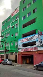 ein grünes Hotel mit davor geparkt in der Unterkunft Holliday Norte Hotel in São Paulo