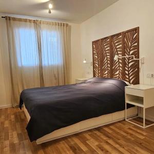 a bedroom with a large bed with a wooden headboard at El Toro Apartments in Altea