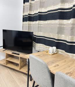 a television on a wooden table with two chairs at Tirana View Apartments in Tirana