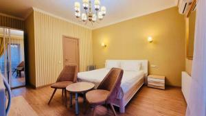 a bedroom with a bed and a table and chairs at ALTYN in Astana
