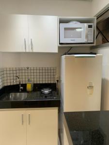 a small kitchen with a sink and a microwave at Royal Ibirapuera Park in Sao Paulo