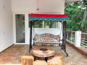 a bench on a porch with a table and benches at Maan Cottages in Rāmgarh