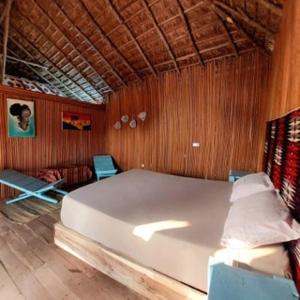 a bedroom with a large white bed and wooden walls at Bel Ami in Ouidah