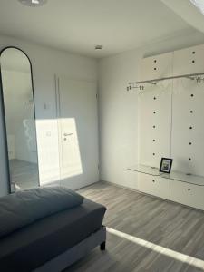 a white room with a bed and some glass cabinets at Baba Apart 1 in Luttingen