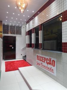 a lobby with a red carpet and a red rug at Holliday Norte Hotel in Sao Paulo