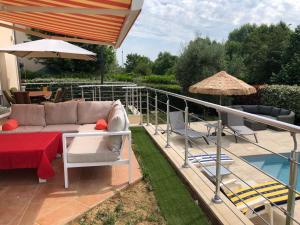 eine Terrasse mit einem Sofa, einem Tisch und einem Sonnenschirm in der Unterkunft 3 Chambres chez particulier pour les 24h du Mans et Jeux olympiques 2024 in Le Mans