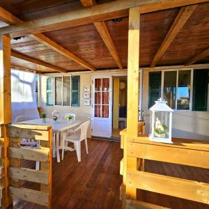 a porch with a table and chairs on a deck at International Holidays Luxe House Pool Beach-Lerici-Cinque Terre-Liguria Case Vacanze in Touristic Village River in Ameglia