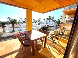 balcón con mesa, sillas y vistas a la piscina en Casa Paraiso, en Playa de Jandía