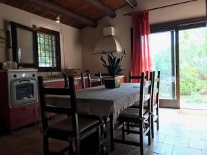 ein Esszimmer mit einem Tisch und Stühlen sowie eine Küche in der Unterkunft Villa Maros in Scicli