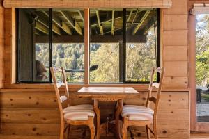 a table and chairs in a cabin with a window at Magical Forest Retreat w Hot Tub, Mt. Tam View, near Muir Woods, 17min to SF in Mill Valley