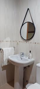 a white bathroom with a sink and a mirror at Residencialusobrasileira in Leça da Palmeira