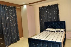 a bedroom with a black bed in a room at The Morville Suites and Apartments in Abeokuta