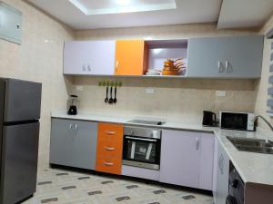 a kitchen with orange and white cabinets and a sink at The Morville Suites and Apartments in Abeokuta