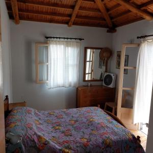 a bedroom with a bed and a dresser and a window at Sunrise house Alonnisos in Alonnisos Old Town