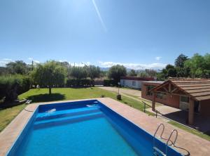 a large swimming pool in a yard with a house at La Vieja Finca in Ciudad Lujan de Cuyo