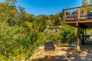 a house with a deck and a chair in a yard at Magical Forest Retreat w Hot Tub, Mt. Tam View, near Muir Woods, 17min to SF in Mill Valley