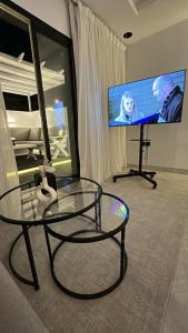 a room with a glass table and a flat screen tv at استوديو أنيق مع سطح خاص بحي الملقا in Riyadh