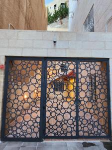 Una puerta con una valla con troncos. en Dair Ghbar - Amman Apartment, en Amán