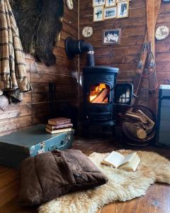 a room with a woodburning stove and books on the floor at Bieszczadzka Osada Saunowisko-dom z jacuzzi sauną na wyłączność in Solina