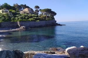 uno specchio d'acqua con case su una costa rocciosa di Casa al Mare a Recco a Recco