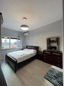 1 dormitorio con 1 cama y TV de pantalla plana en Tirana Gallery Apartment - City Center View, en Tirana