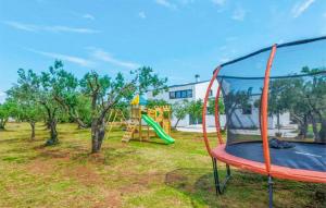 - un parc avec une aire de jeux dotée d'un trampoline dans l'établissement 4 Bedroom Stunning Home In Rakalj, à Rakalj