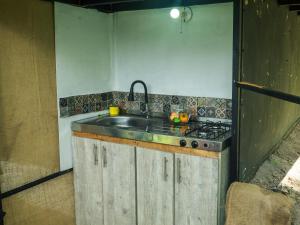 a kitchen with a sink and a stove at SELVA ADENTRO in Norcasia