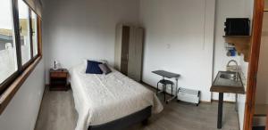 - une petite chambre avec un lit et un lavabo dans l'établissement MARITIMO SUITE, à Los Vilos
