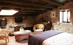 sypialnia z łóżkiem, krzesłami i telewizorem w obiekcie A Casa de Filomena w mieście Boiro
