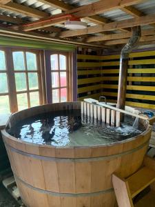 una gran bañera de madera llena de agua en una habitación en Butamacho Cabaña con Tinaja x Día, en Chonchi