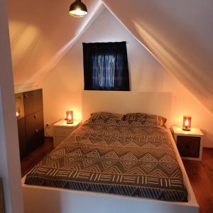 1 dormitorio con 1 cama y 2 luces en 2 mesas en Huisje in Słup, 