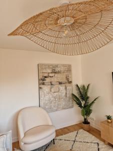 een woonkamer met een stoel en een grote ventilator bij Appartement Enghien-les-Bains à 7 min du Casino Barrière in Enghien-les-Bains