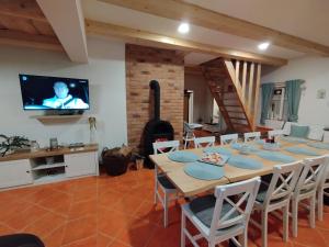 a dining room with a table and a tv at Chalupa u Markéty in Jiřetín pod Jedlovou